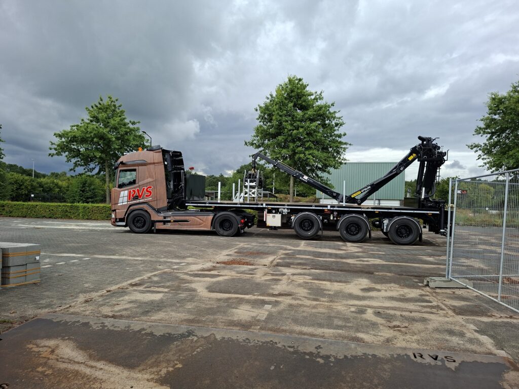Kraanwagen van RVS Rijplaten legt stalen rijplaten op een bouwterrein, rijplaten huren in Dalfsen en omgeving