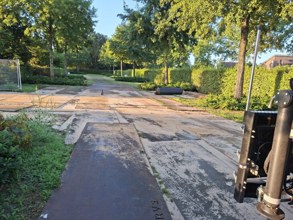 Tijdelijke rijplatenbaan van stalen rijplaten over een gazon ter bescherming van de ondergrond, RVS Rijplaten Dalfsen