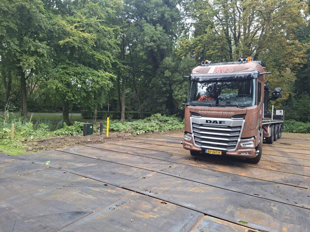 Vrachtwagen van RVS Rijplaten legt stalen rijplaten op een bouwterrein, rijplaten verhuur Dalfsen