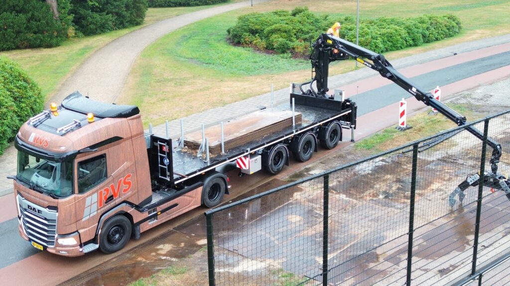Dronefoto van de DAF kraanwagen met rijplaten bij de aanleg van het kunstgrasveld in Enschede