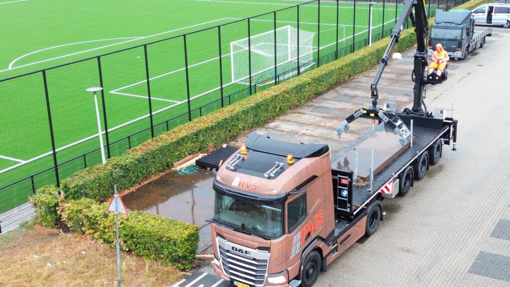 Dronefoto van de kraanwagen van RVS Rijplaten naast het kunstgrasveld van Universiteit Twente in Enschede