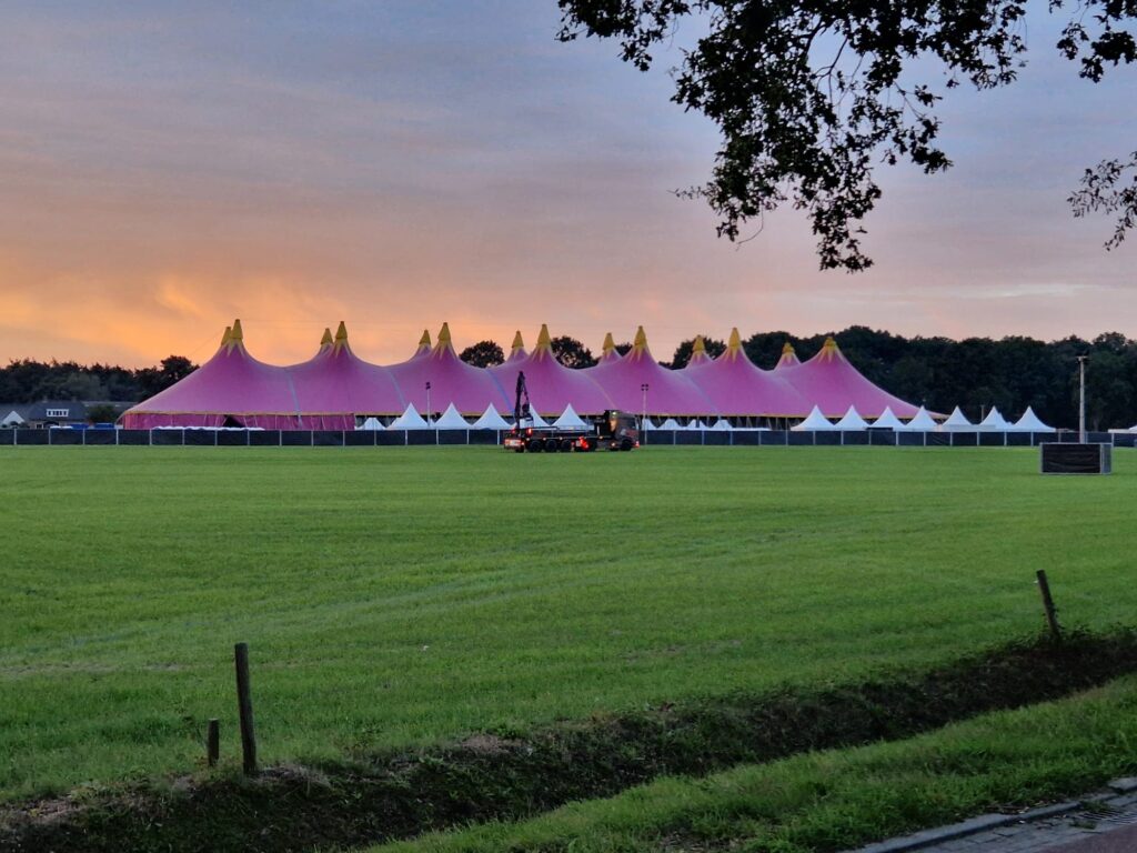 Festivaltent van Normaal Dalfsen bij avondlicht met de rijplatenvrachtwagen op het terrein