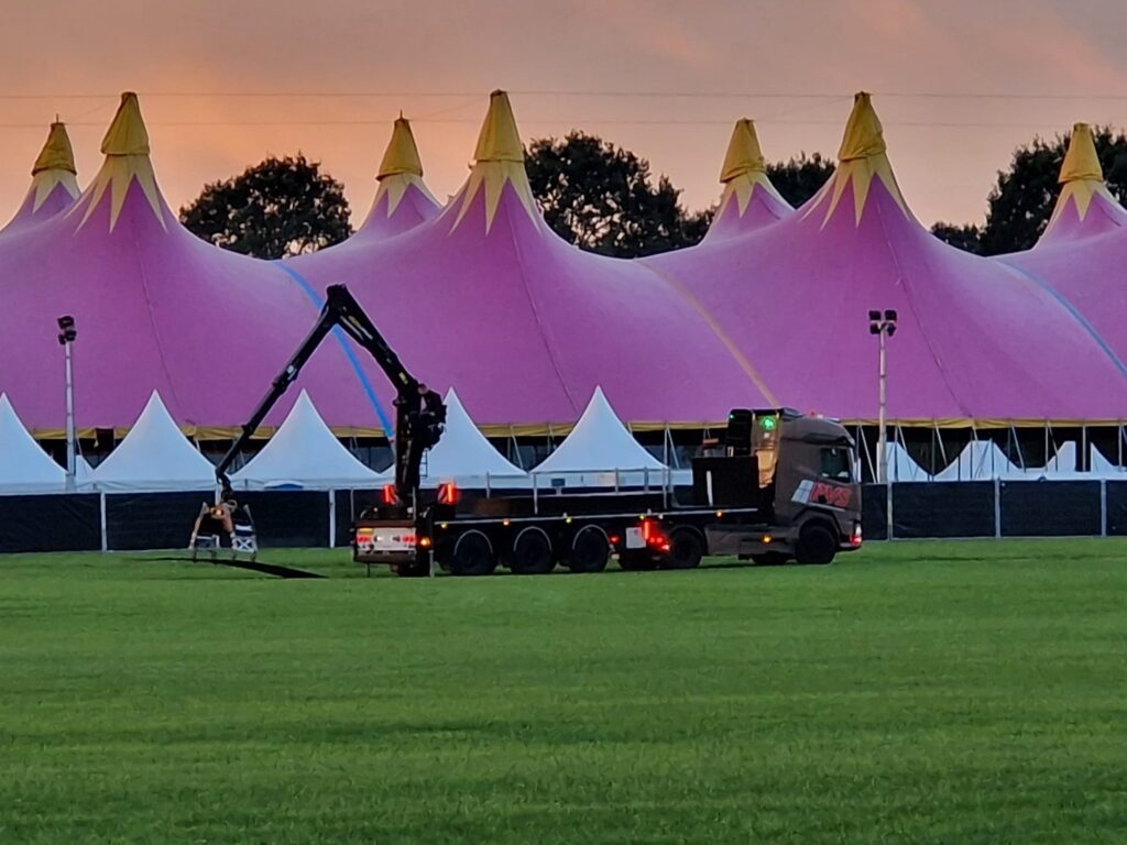 Rijplaten lossen met de kraan naast de festivaltent van Normaal Dalfsen