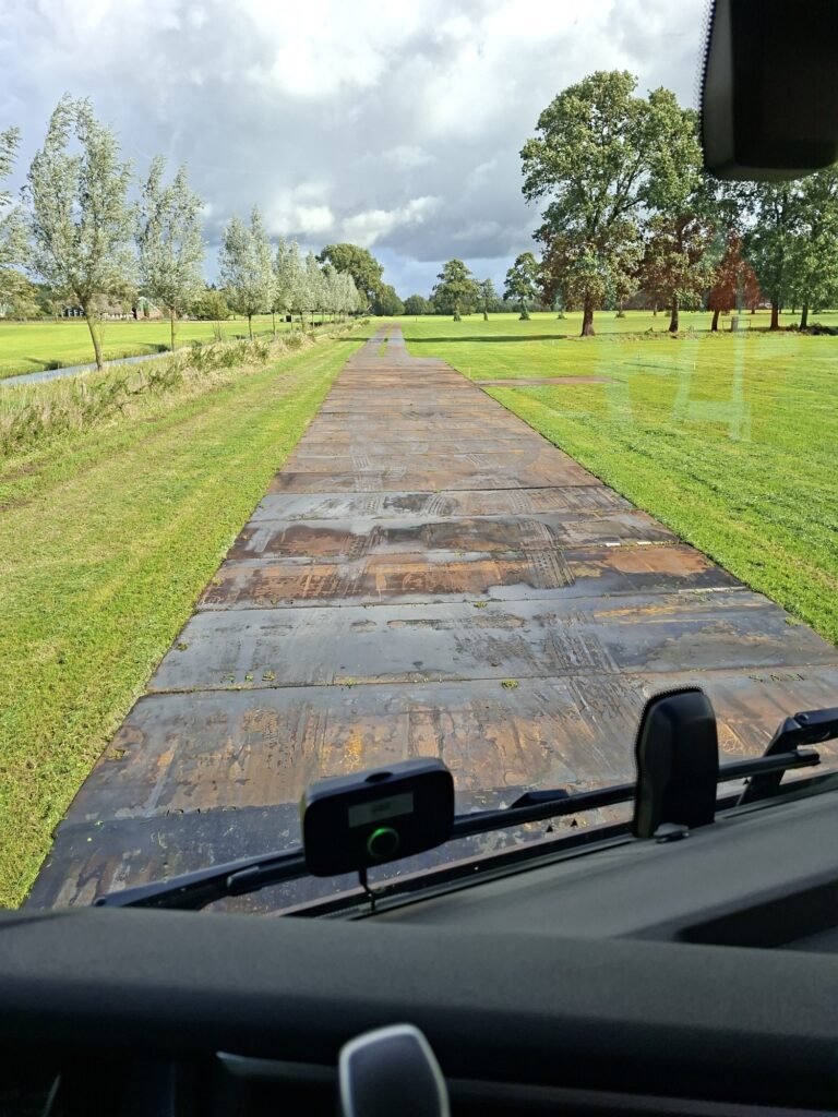 Rijplatenweg over het grasveld bij Kachel FM Hoonhorst, gezien vanuit de cabine